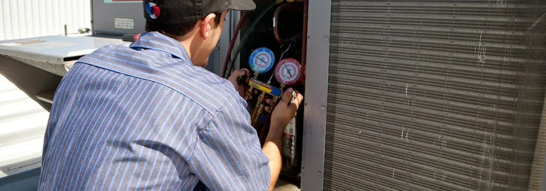 HVAC technician servicing a condenser unit in Wrightsboro